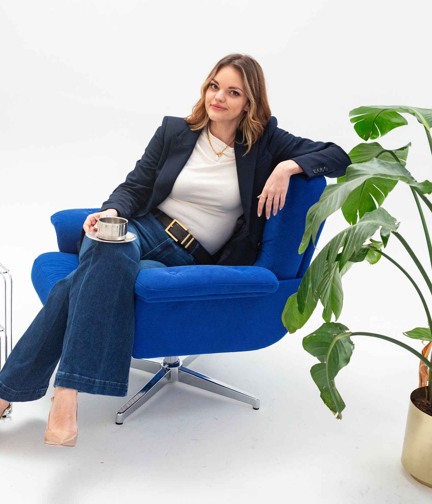 Kirsty Hulse sitting in a blue armchair with a cup of coffee